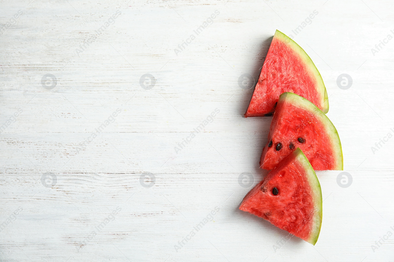 Photo of Flat lay composition with watermelon slices on white wooden background