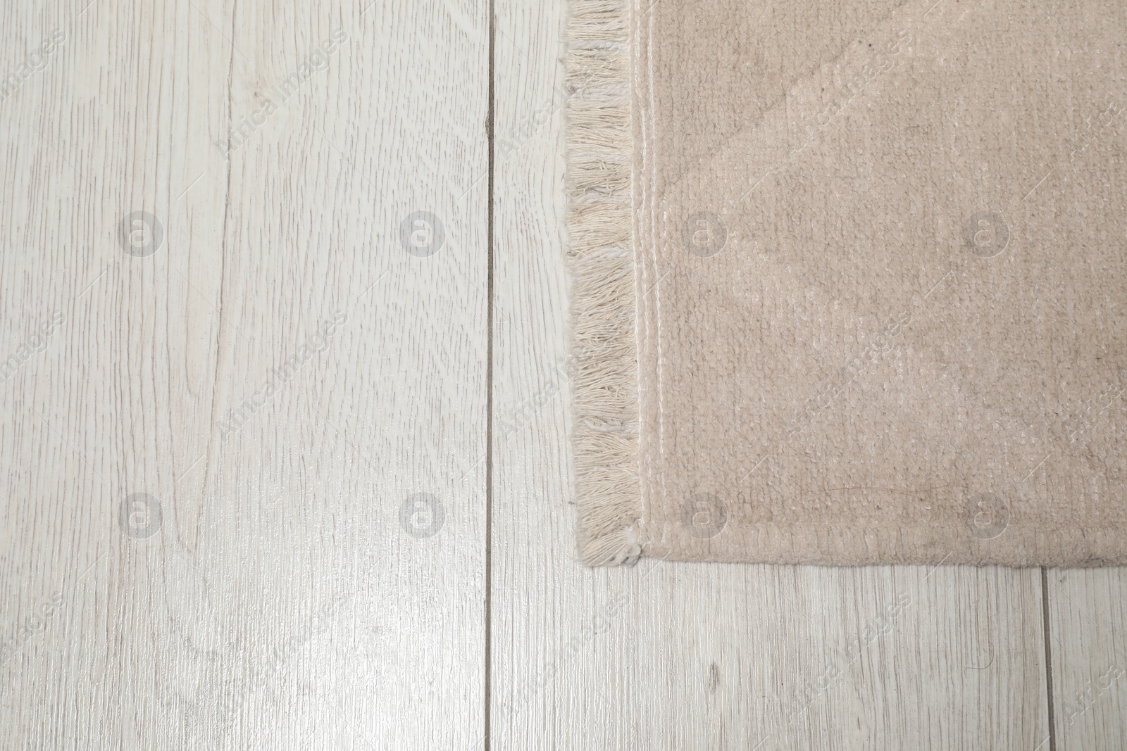 Photo of Soft beige carpet on white laminated floor indoors, top view. Space for text