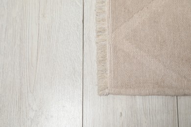 Photo of Soft beige carpet on white laminated floor indoors, top view. Space for text