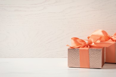 Photo of Beautiful gift boxes on white table, space for text