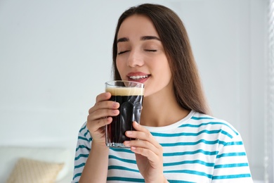 Beautiful woman with cold kvass indoors. Traditional Russian summer drink