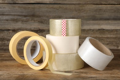 Photo of Many rolls of adhesive tape on wooden table