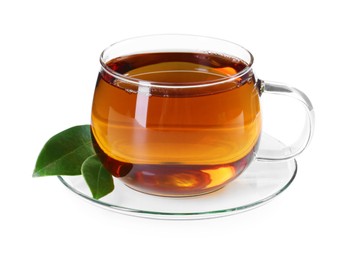 Aromatic tea in glass cup and green leaves isolated on white