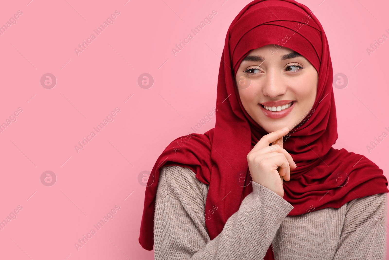 Photo of Portrait of Muslim woman in hijab on pink background, space for text