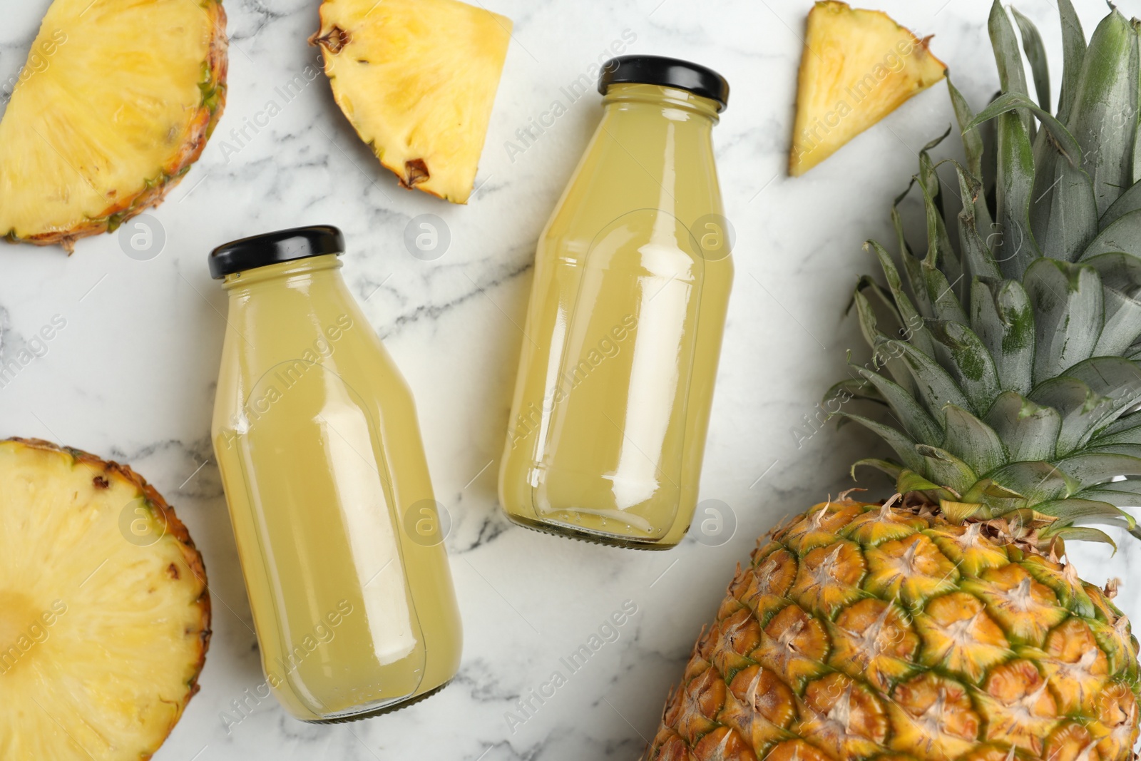 Photo of Delicious pineapple juice and fresh fruit on white marble table, flat lay