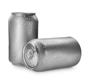 Aluminum cans of beverage covered with water drops on white background. Space for design