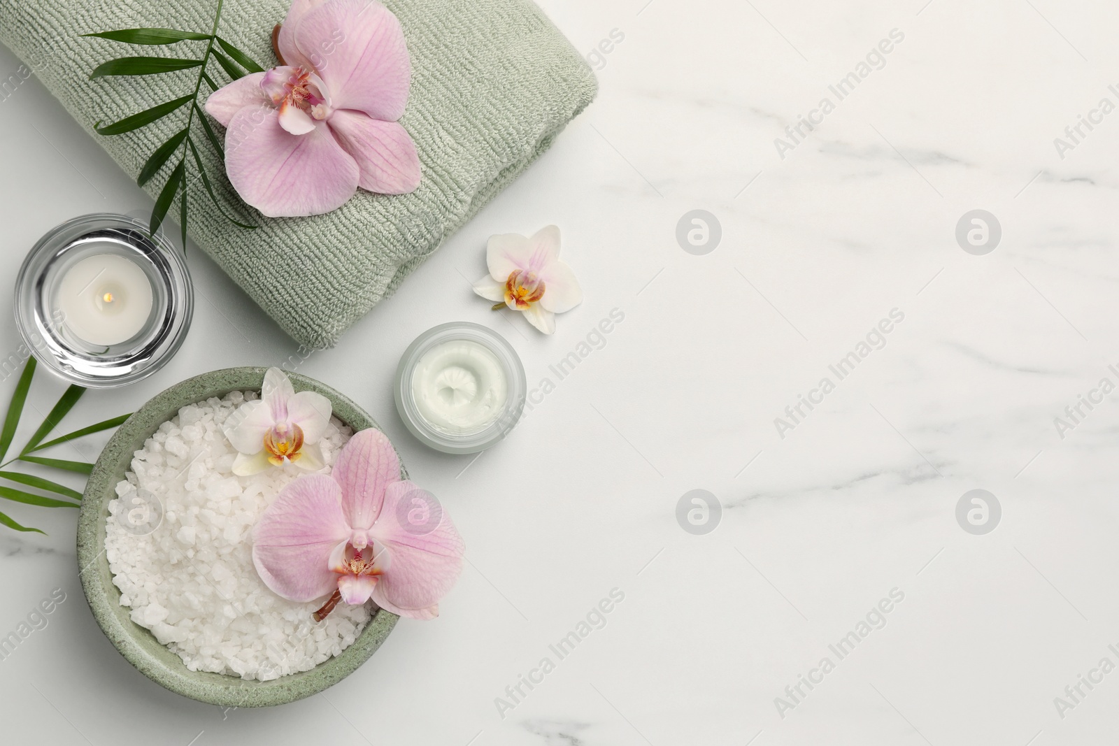 Photo of Flat lay composition with different spa products and flowers on white marble table. Space for text