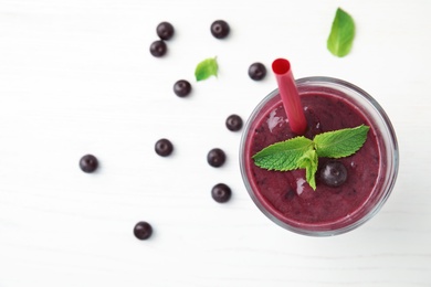 Glass with delicious acai smoothie on table, top view