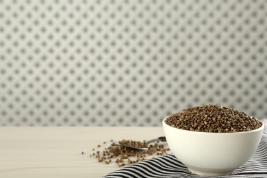 Photo of Ceramic bowl with chia seeds on white wooden table, space for text. Cooking utensils