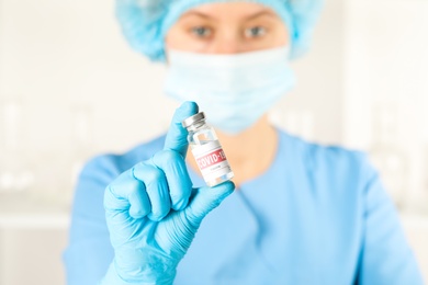 Photo of Doctor with coronavirus vaccine in laboratory, focus on hand