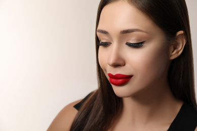 Photo of Beautiful woman with red lipstick on light background, space for text