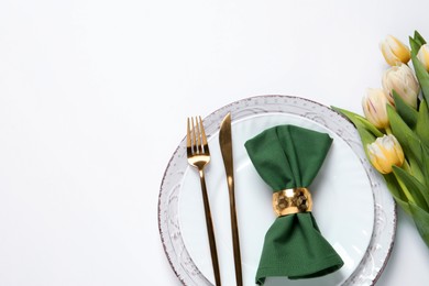 Photo of Stylish table setting with cutlery and flowers on white background, flat lay. Space for text