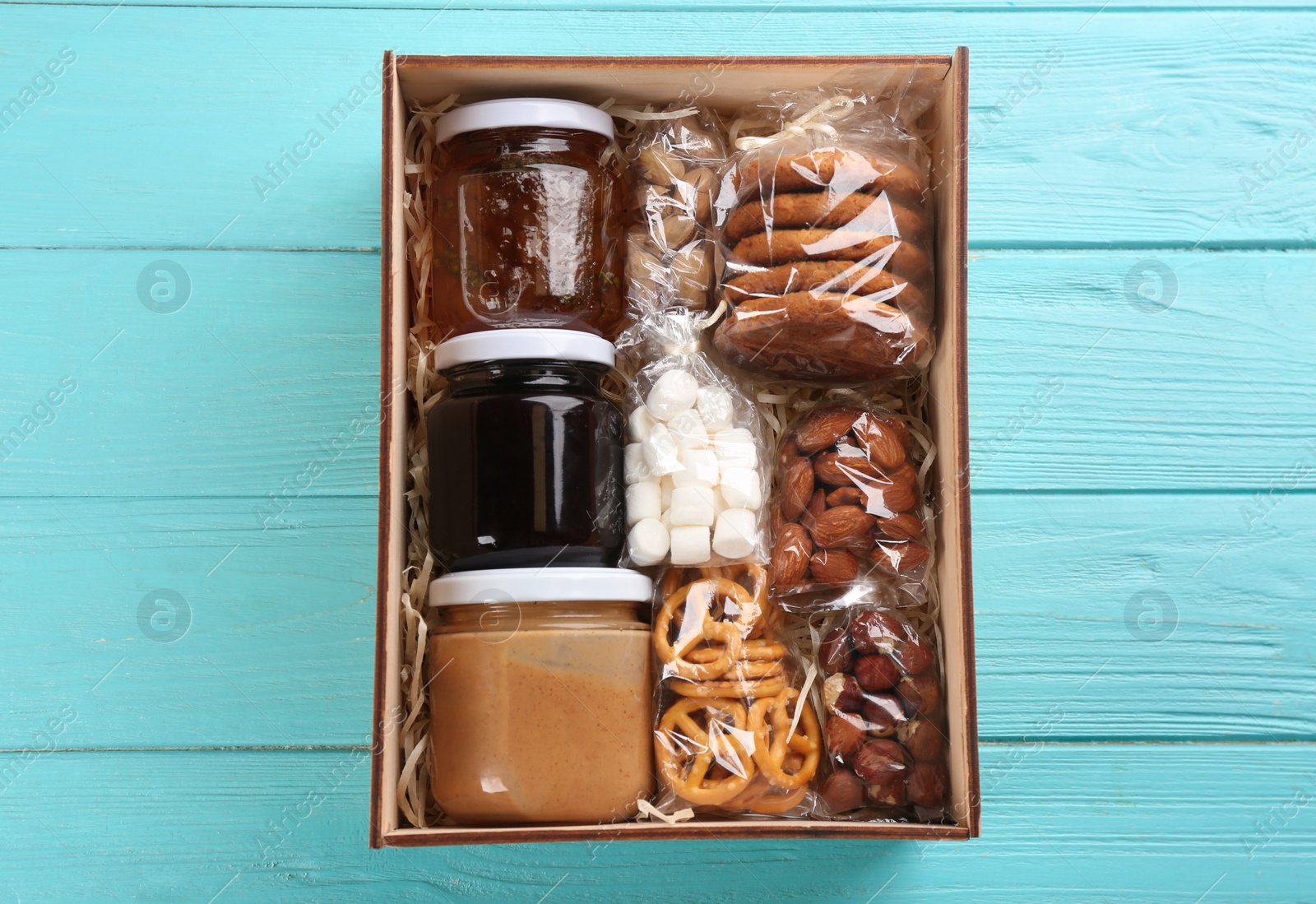 Photo of Box with stylish craft gift set on light blue wooden table, top view