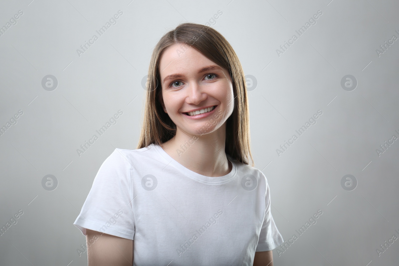 Photo of Portrait of beautiful happy woman on light grey background