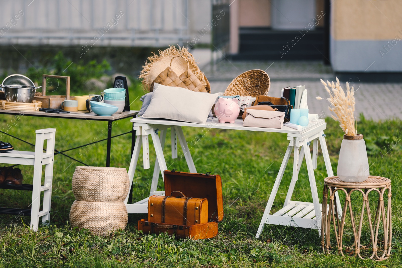 Photo of Small tables with many different items on garage sale in yard