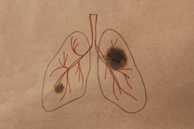 Drawn human lungs with cigarette holes on kraft paper, top view. No smoking concept