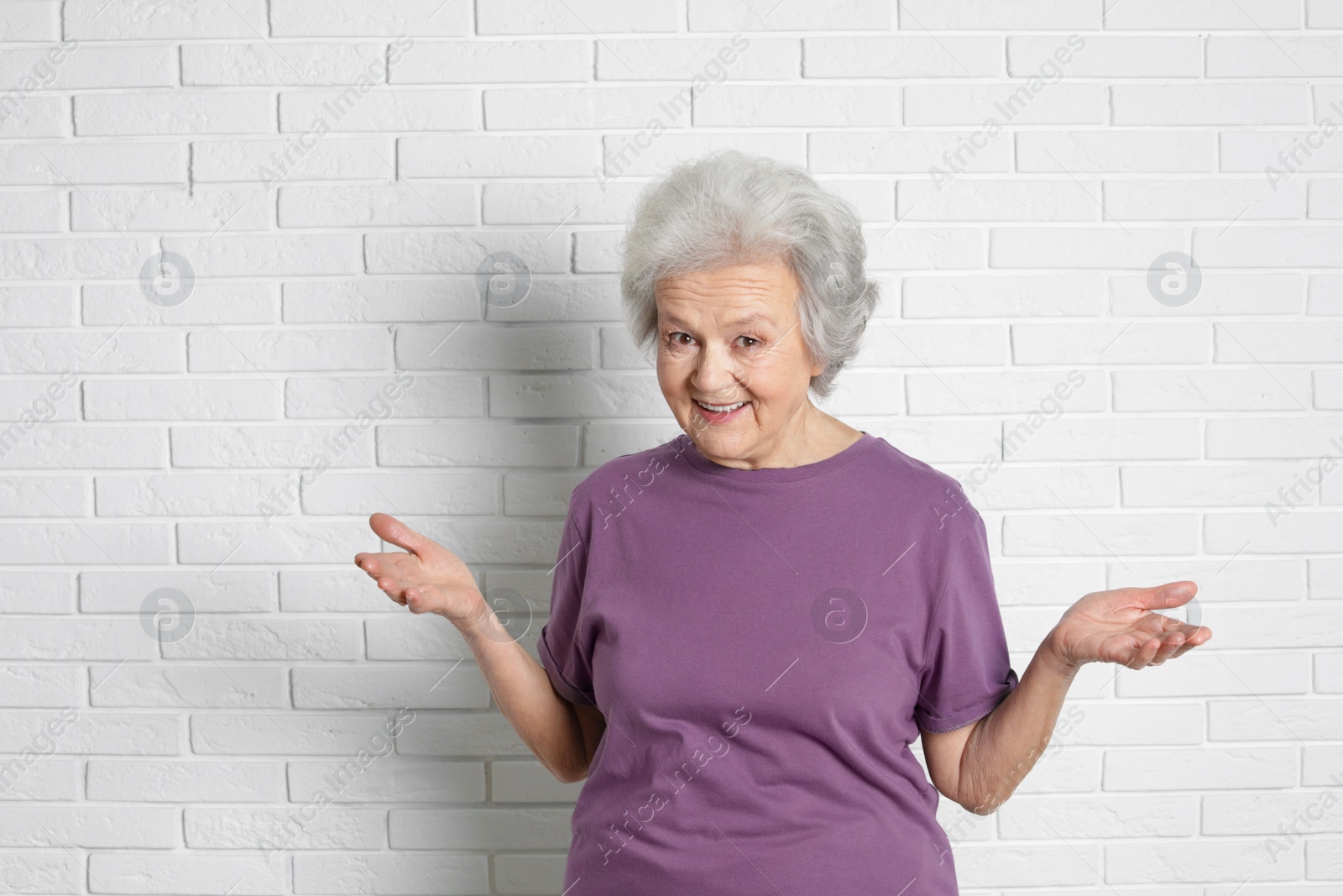 Photo of Portrait of mature woman near brick wall