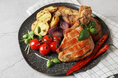Photo of Delicious grilled meat and vegetables on light grey table, closeup
