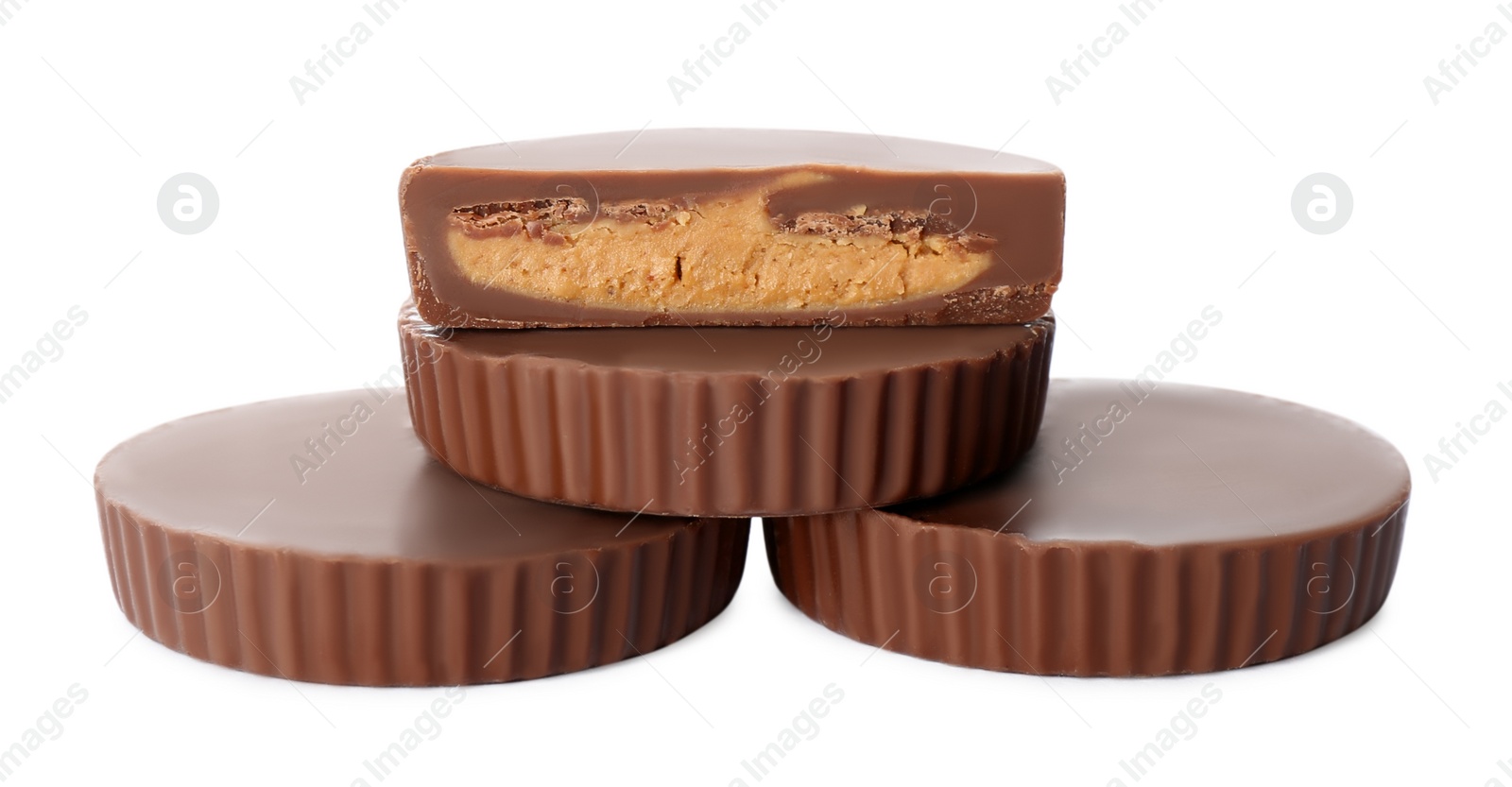 Photo of Cut and whole delicious peanut butter cups on white background