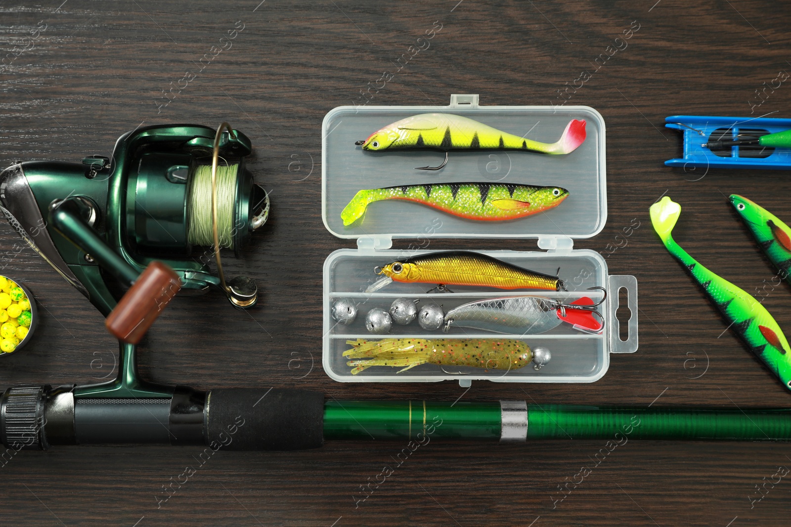 Photo of Fishing tackle on dark wooden background, flat lay