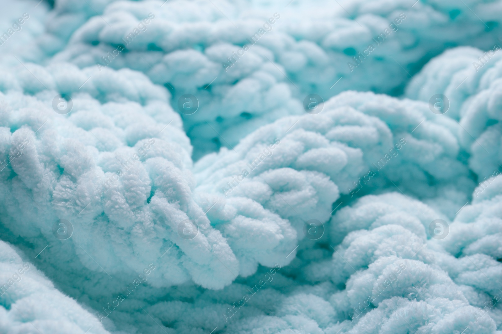 Photo of Soft light blue knitted fabric as background, closeup