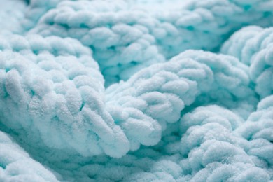 Photo of Soft light blue knitted fabric as background, closeup