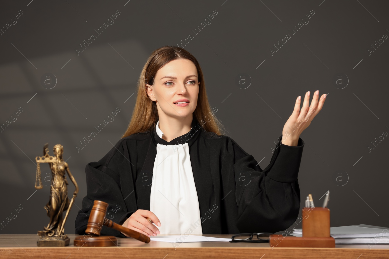 Photo of Judge discussing with somebody at table indoors