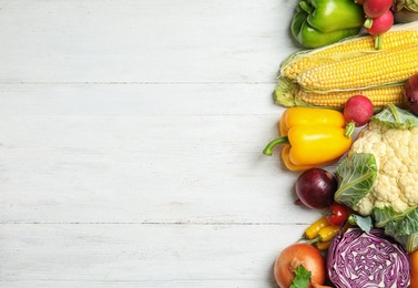 Photo of Flat lay composition with assortment of fresh vegetables on wooden background. Space for text