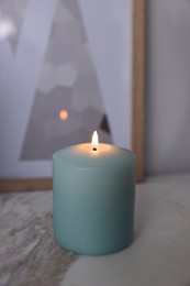 Beautiful burning candle on marble table, closeup
