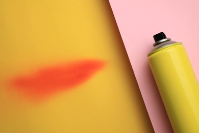 Can of graffiti paint and sprayed dye sample on color background, top view