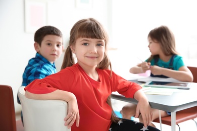Photo of Cute little girl in classroom at school