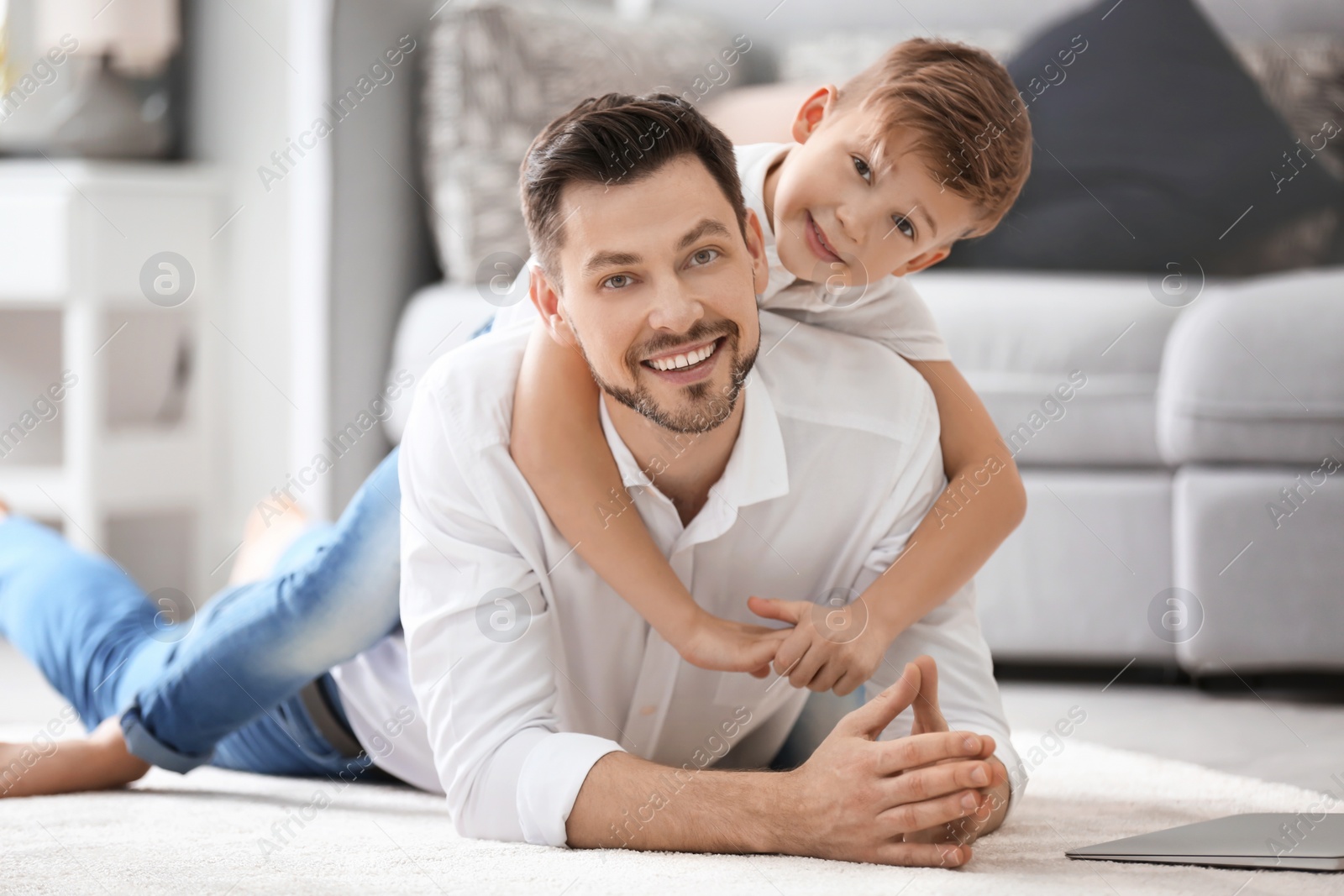 Photo of Little boy and his dad spending time together at home