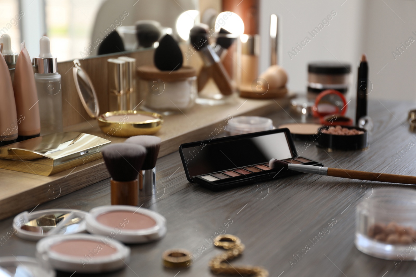 Photo of Many different cosmetic products on dressing table indoors