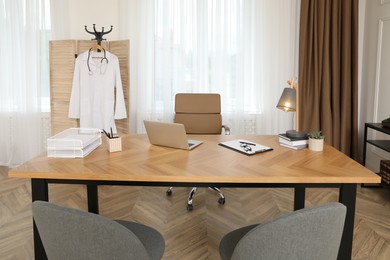 Modern medical office interior with doctor's workplace and chairs