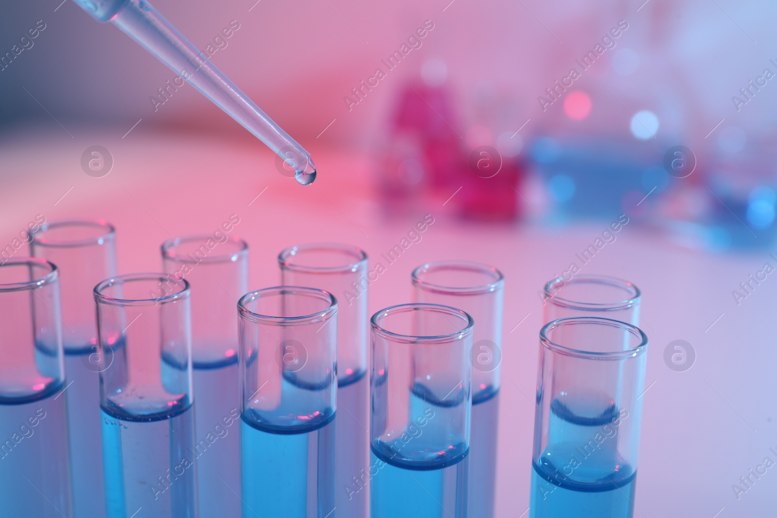 Photo of Dripping reagent into test tube with blue liquid, closeup. Laboratory analysis