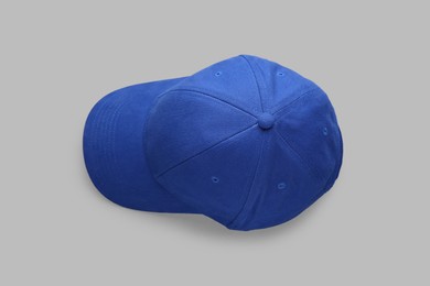 Stylish blue baseball cap on light grey background, top view