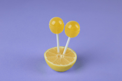 Fresh lemon with yellow lollipops on light blue background