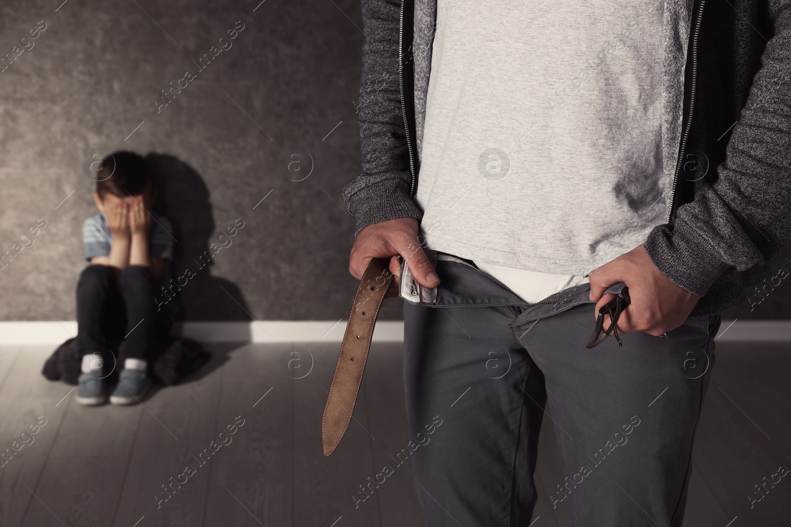 Photo of Man with unzipped pants and scared little boy indoors. Child in danger