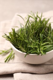 Bowl with fresh green rosemary on table, closeup