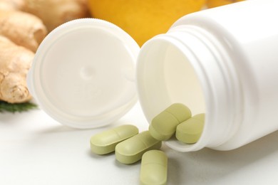 Photo of Dietary supplements in plastic bottle on white table, closeup