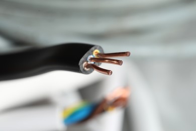 Photo of Black electrical wire on blurred background, closeup