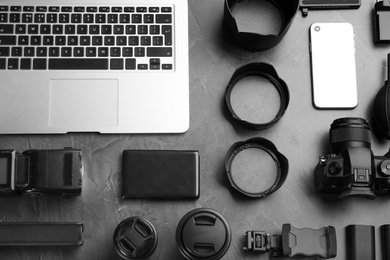 Flat lay composition with camera and video production equipment on grey stone background