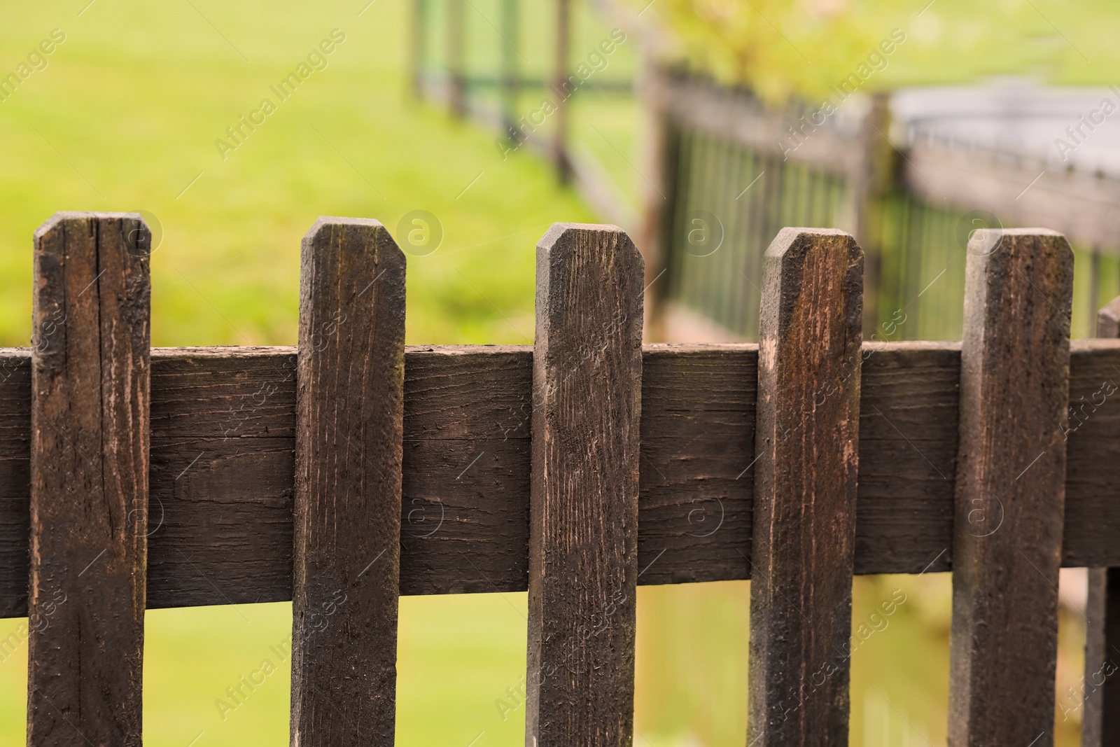 Photo of Old wooden fence in park, closeup view