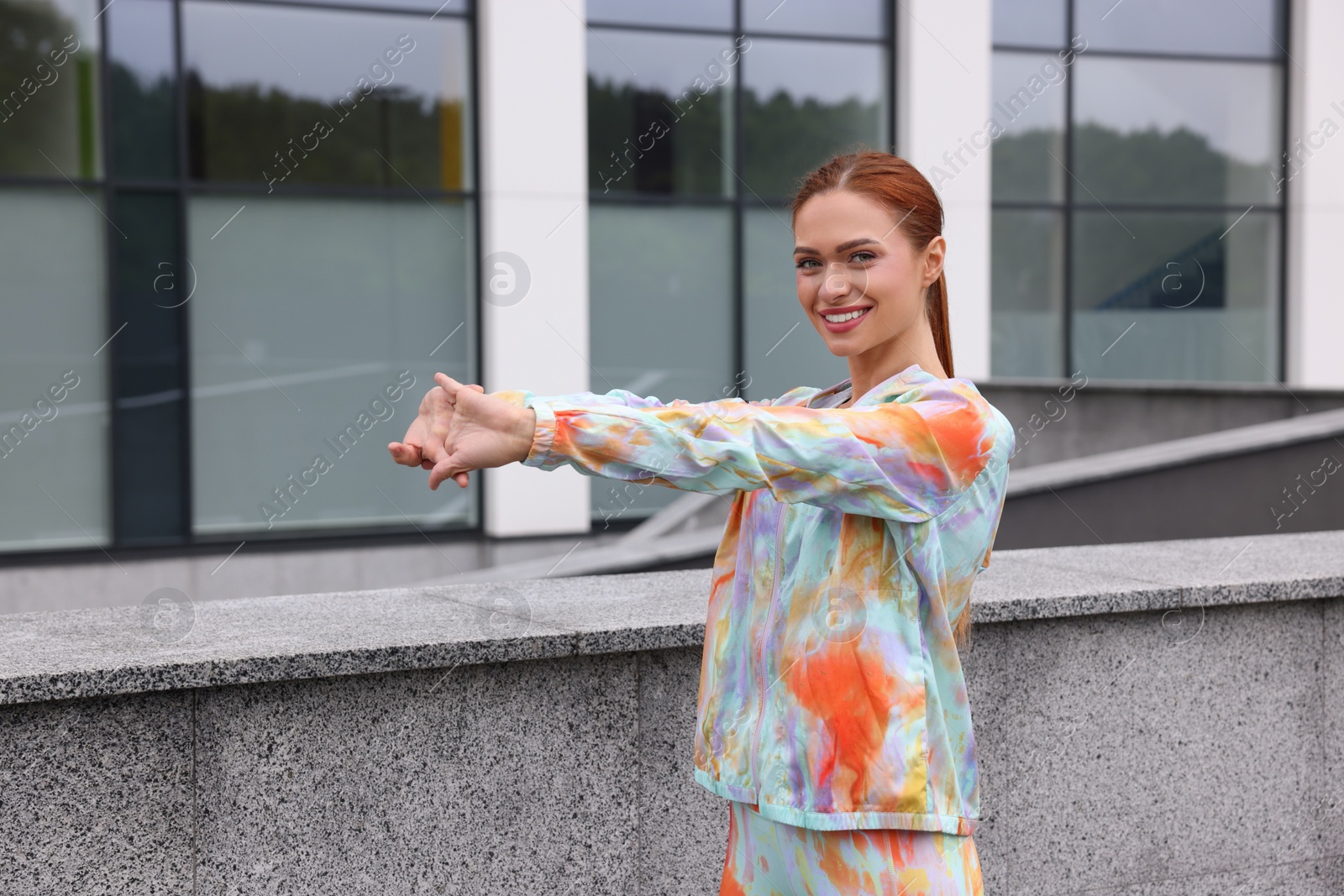 Photo of Beautiful woman in gym clothes doing exercises on street