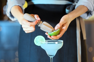 Photo of Bartender making fresh alcoholic cocktail, closeup view