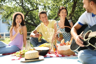 Young people enjoying picnic in park on summer day