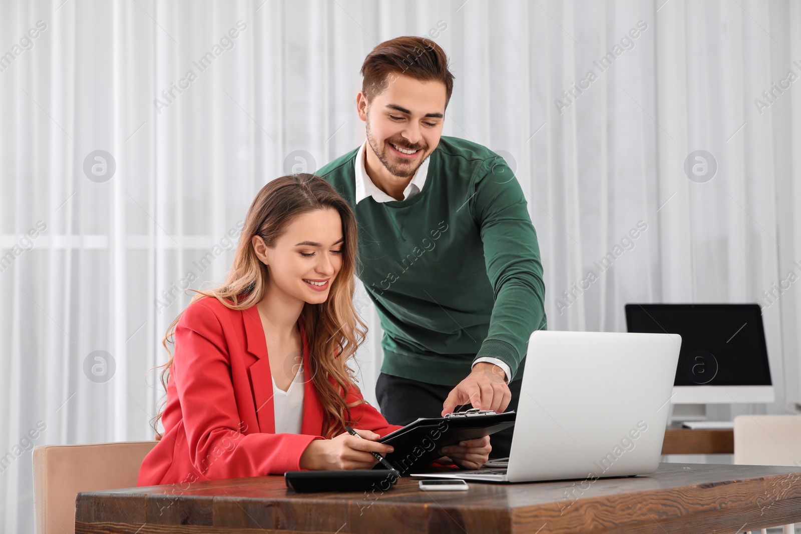 Photo of Young man helping his colleague in office