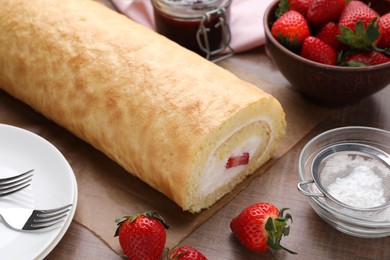 Photo of Delicious sponge cake roll with strawberries and cream on wooden table