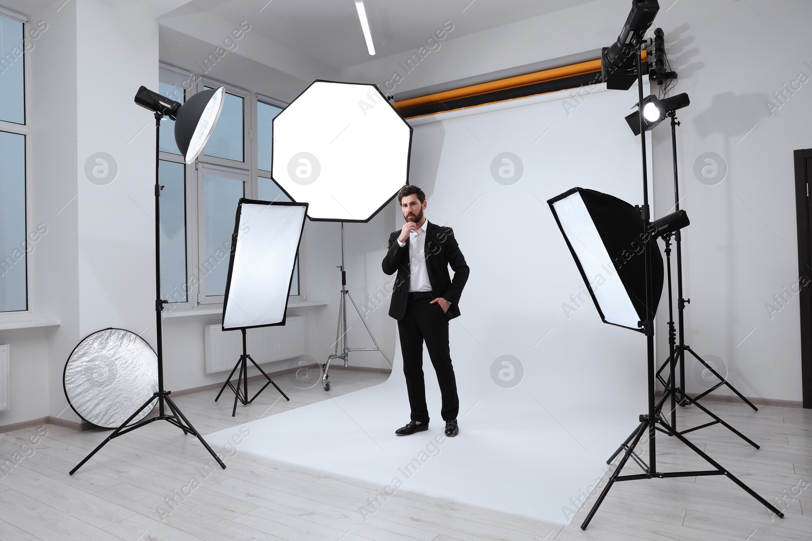 Photo of Handsome model posing in modern studio. Professional photo session