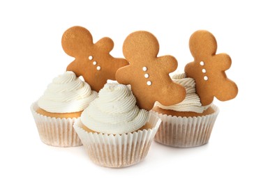 Tasty Christmas cupcakes with gingerbread men on white background